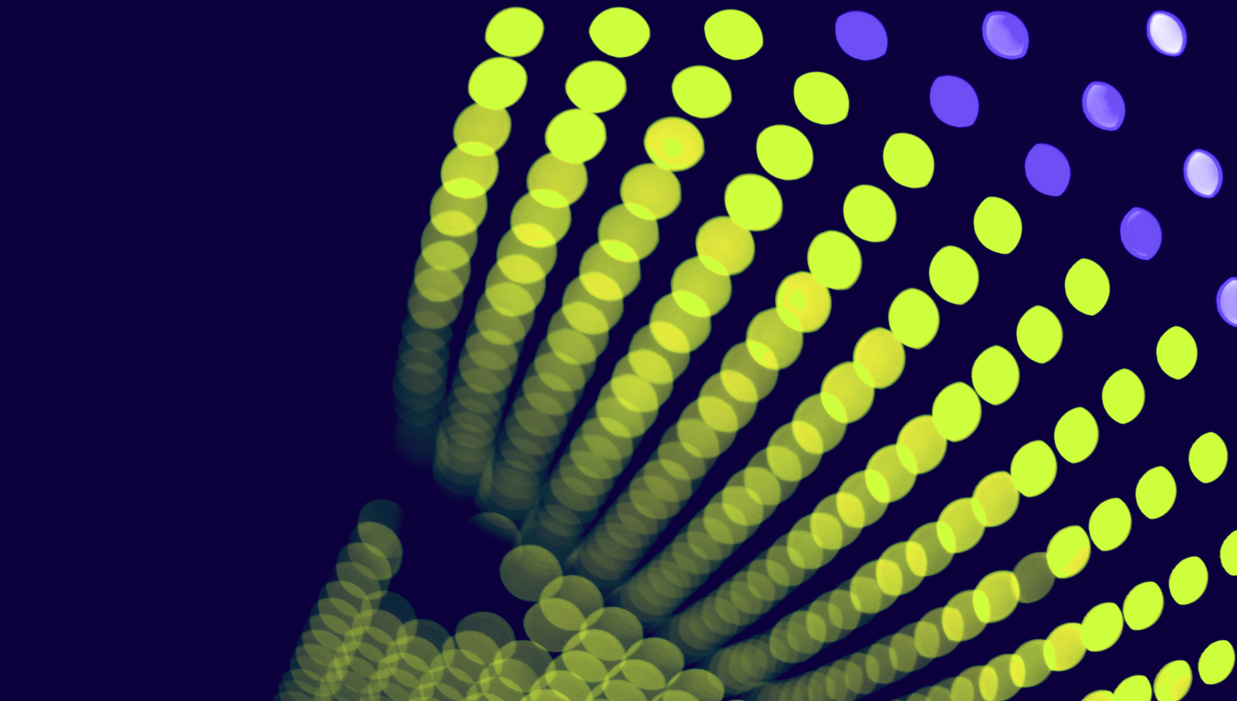 Two women sitting at a modern table talking with a city view behind them.